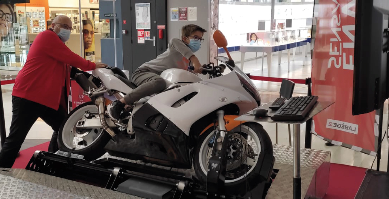 L'événement Fou de courses au centre commercial Labège 2. Un client sur le simulateur moto