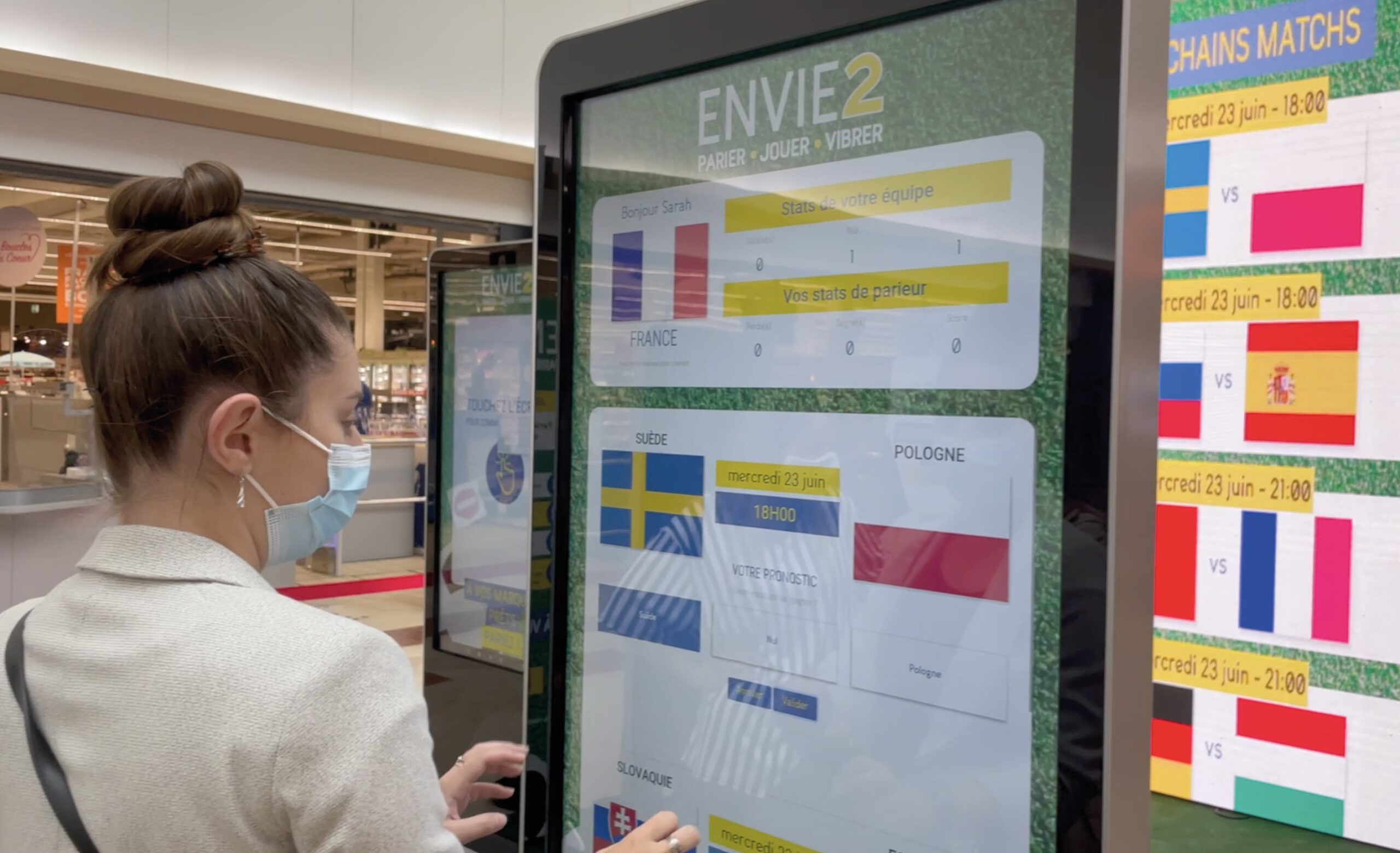 Une cliente du centre commercial entrain de parier sur une borne digitale